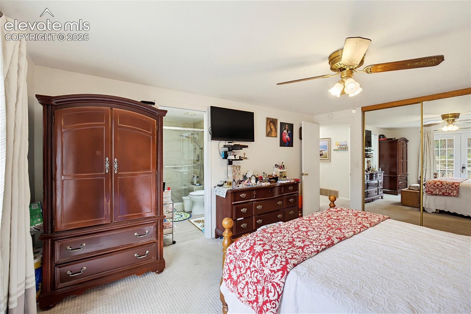 Wall-to-wall carpeting, mirrored closet doors, and an attached ceiling fan with lighting