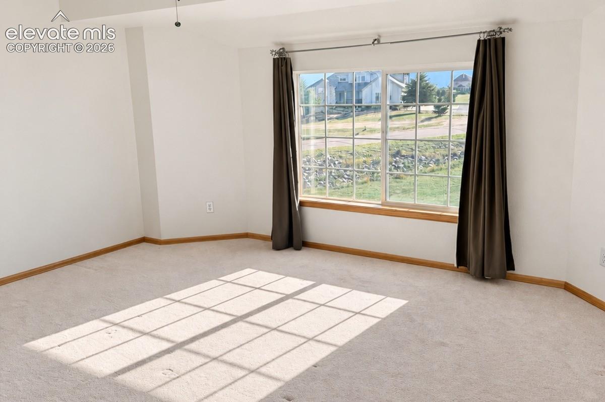 Upstairs bedroom 1/3. Unstaged. Bright room featuring a large window, neutral carpeting, ceiling fan, & large walk-in closet. No staging.