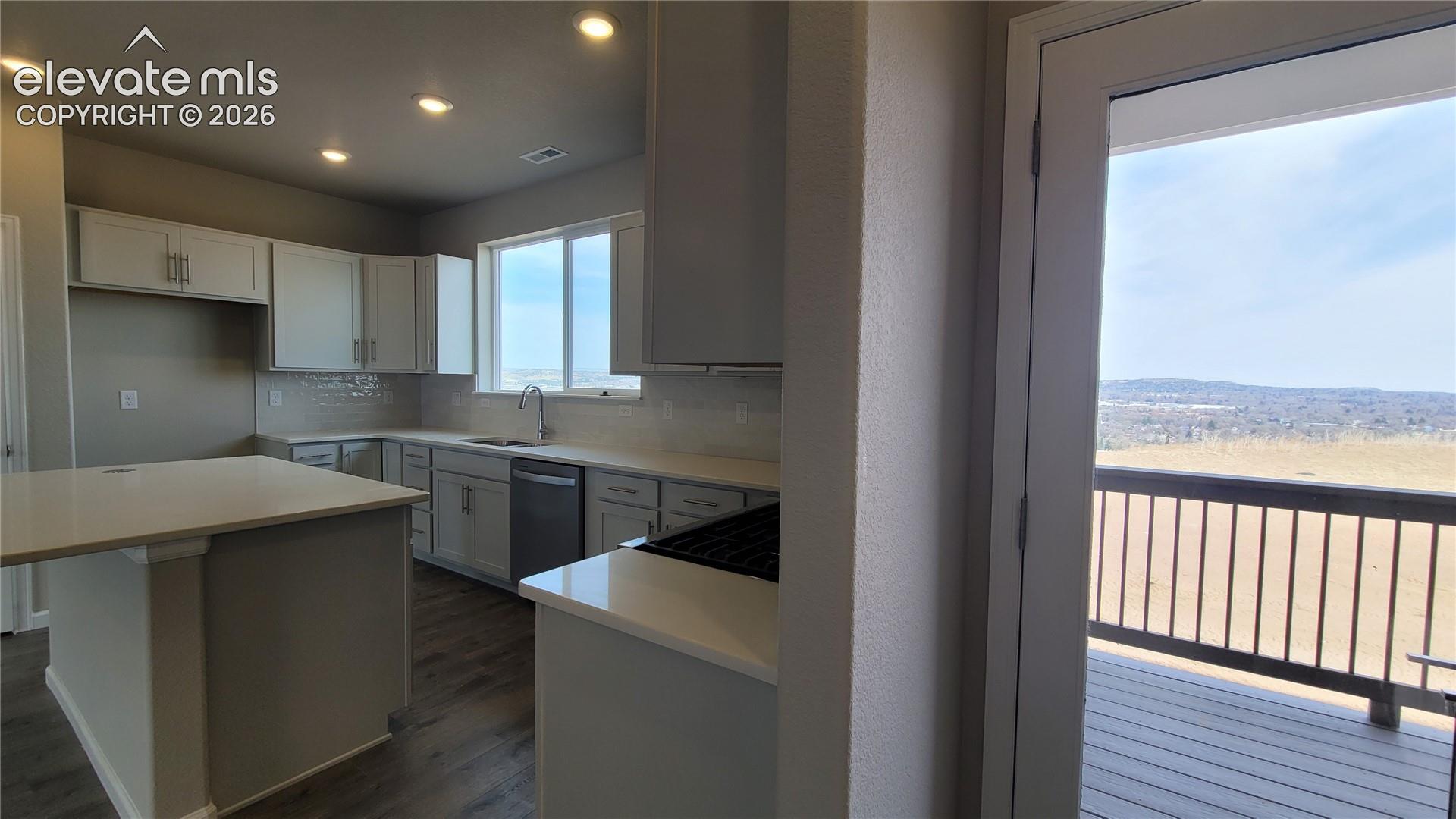 Kitchen with quartz countertops, pantry, large island providing additional seating, and stainless steel gas range, microwave, and dishwasher! 