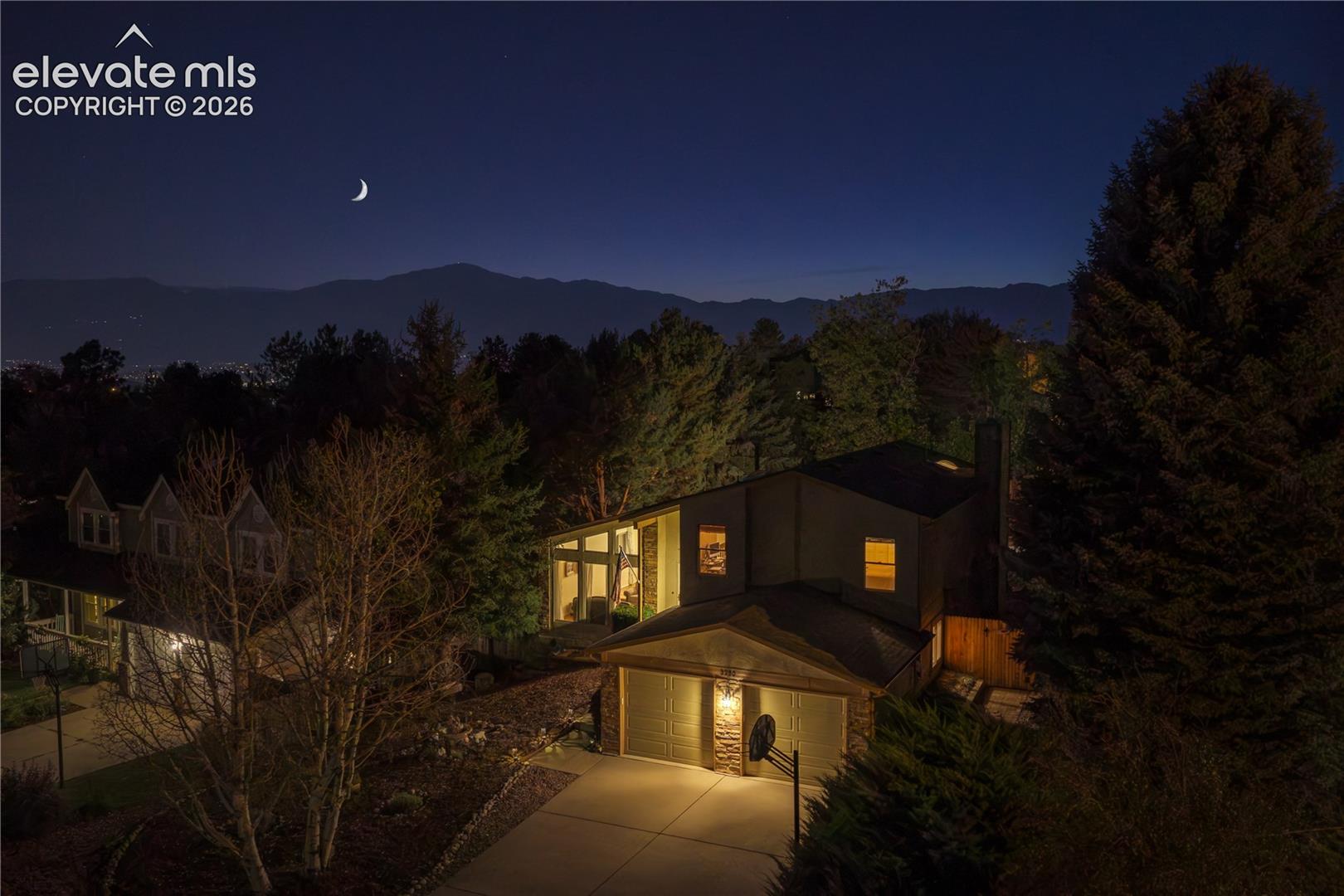 Contemporary exterior design with an attached two-car garage, stone accents, and a sloped roofline