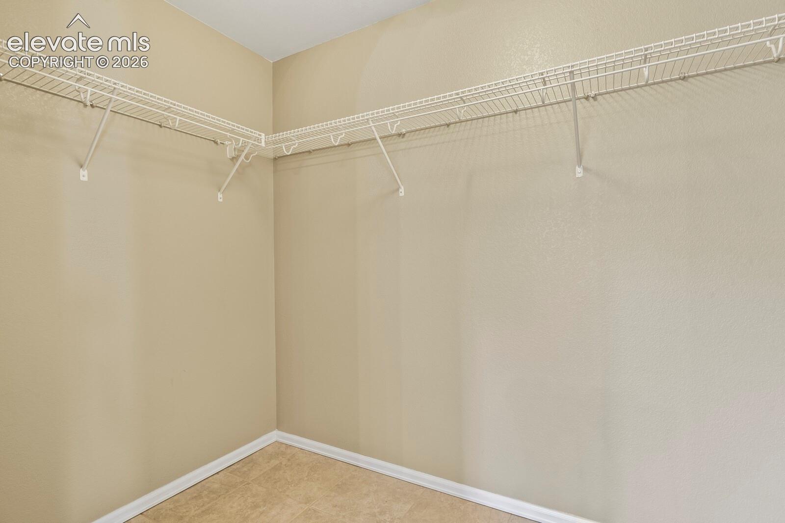 Master Bedroom Walk in closet with wire shelving system and neutral wall paint