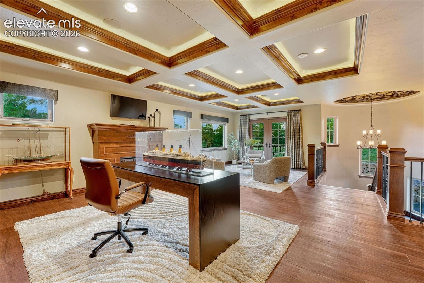 Coffered ceiling with recessed lighting, wood-finish flooring, French doors, iron railing, and a decorative ceiling medallion
