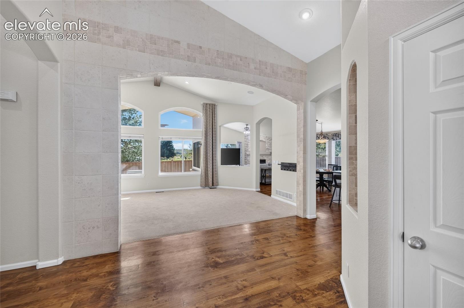 Entry opens to vaulted ceilings and hardwood floors