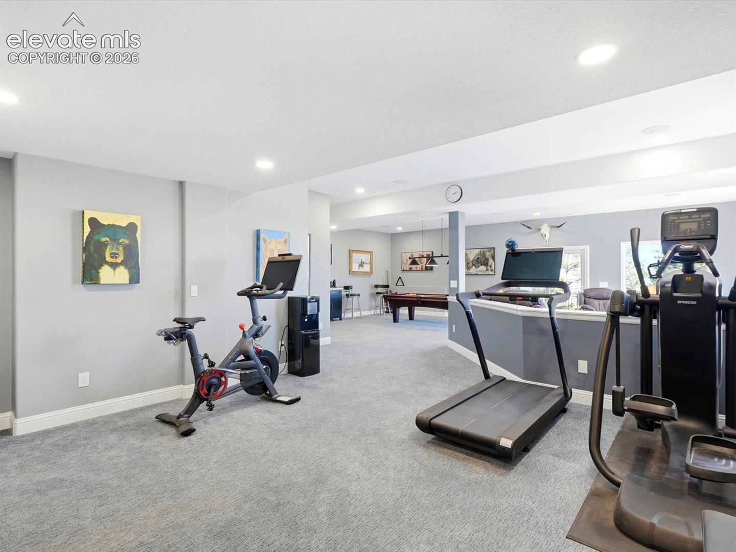 Expansive walk out interior space featuring neutral wall tones, recessed lighting, wall-to-wall carpeting, and a half-wall partition