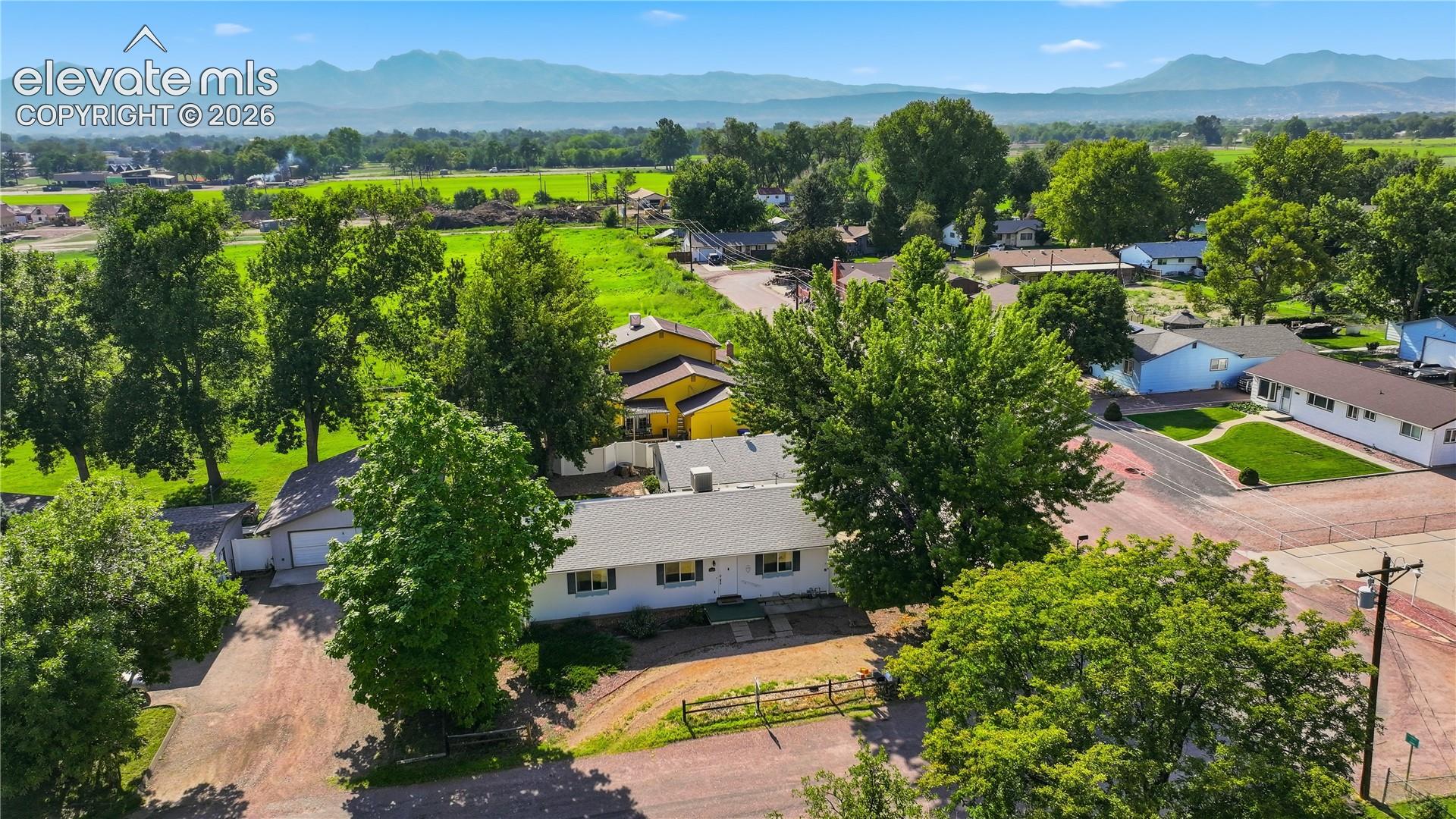 Aerial view highlights the home’s setting in an established neighborhood near the historic Abbey, with open surroundings and beautiful mountain backdrop.