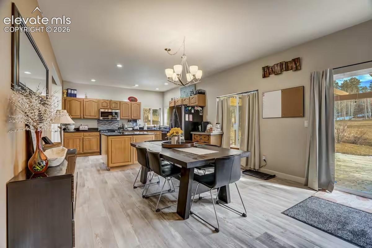 Open-concept kitchen and dining area featuring wood-finish flooring