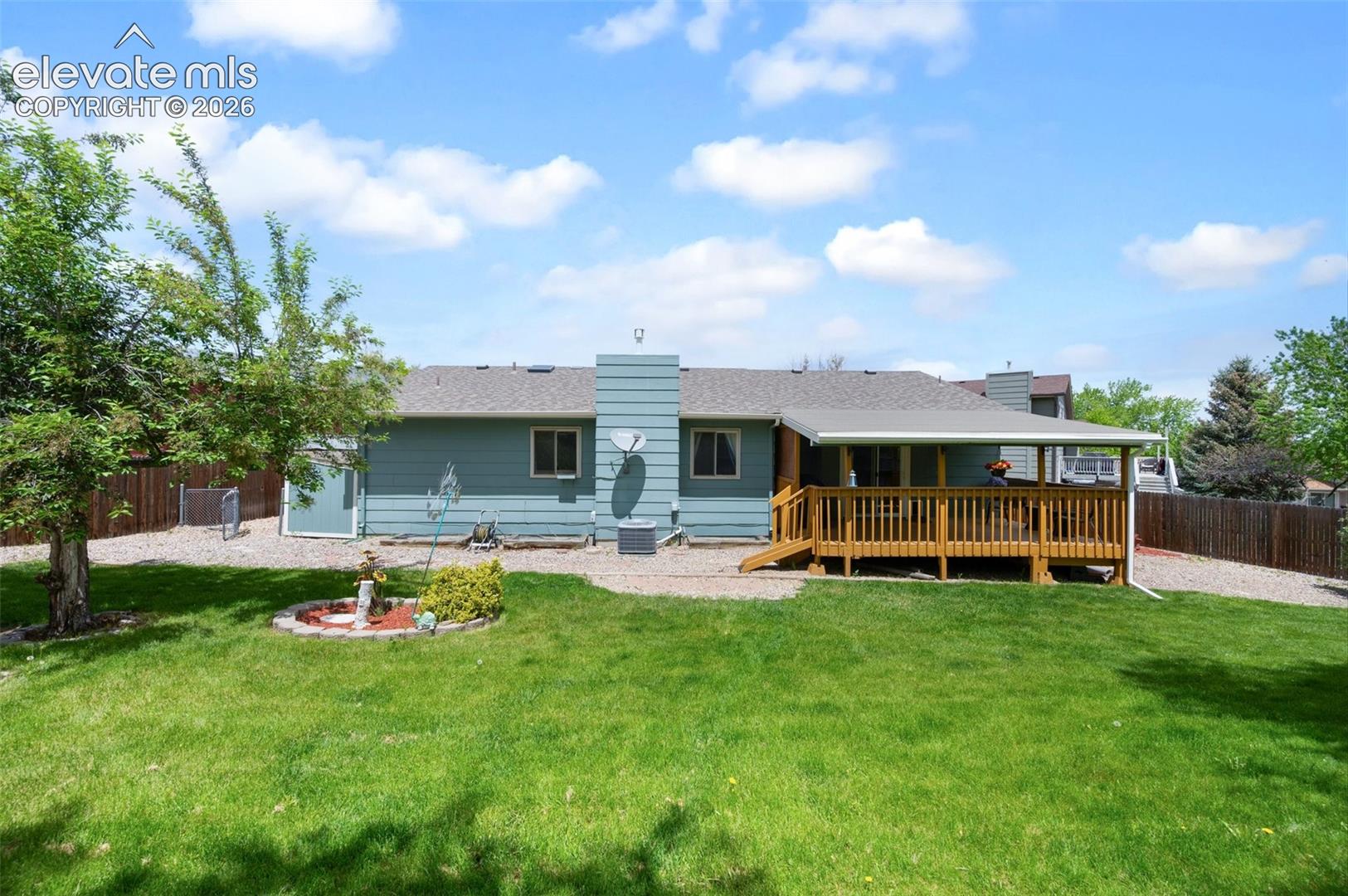 Rear view of property featuring a wooden deck and a chimney