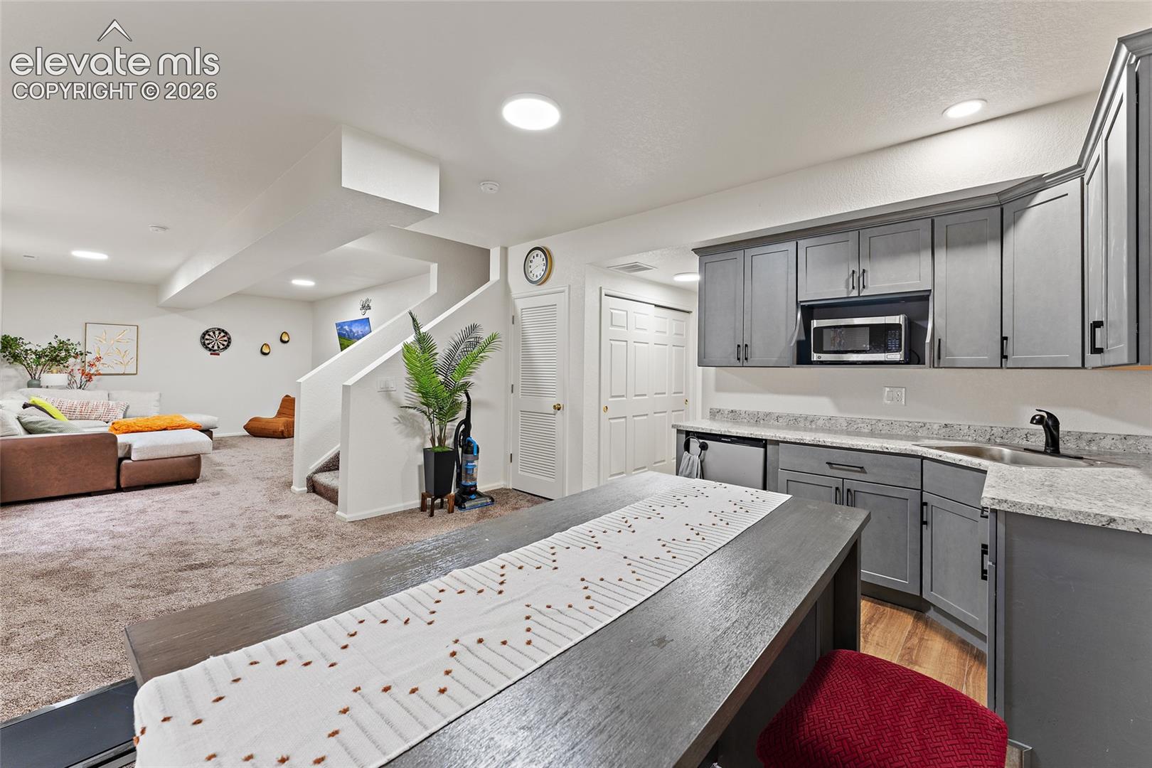 Kitchenette featuring gray cabinetry, stone-finish countertops, built-in microwave, and recessed lighting