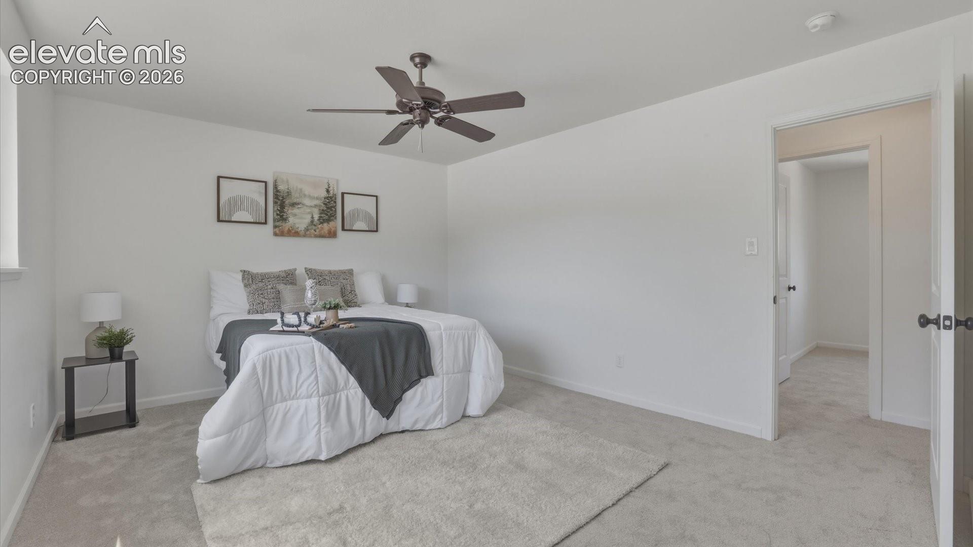  The spacious primary bedroom includes a ceiling fan and private bath access. 