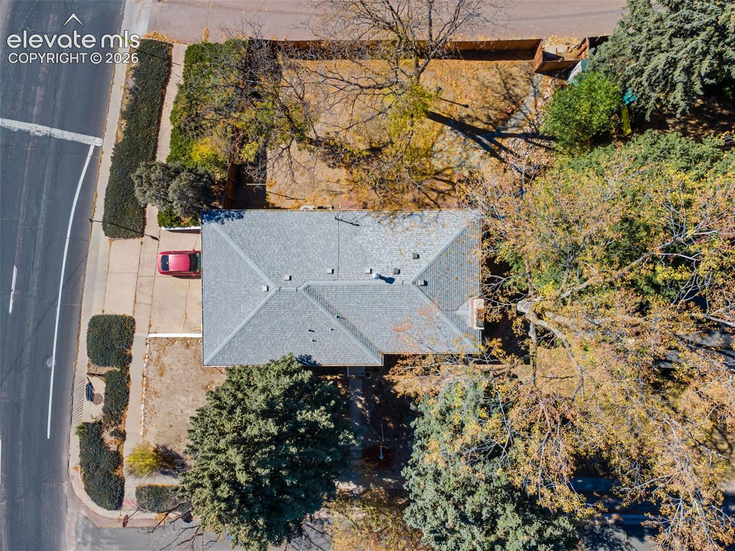 Gable roof home with a gray shingle roof, chimney, and extended driveway