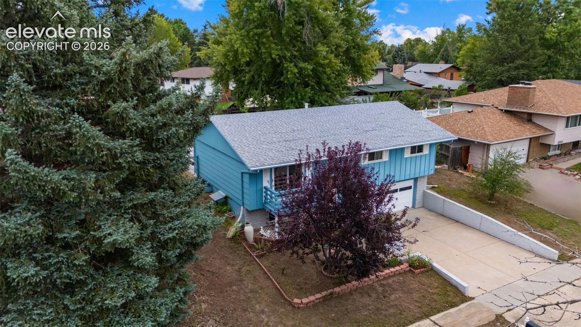 Two-story residence with blue siding, a shingle roof, and a single-car garage