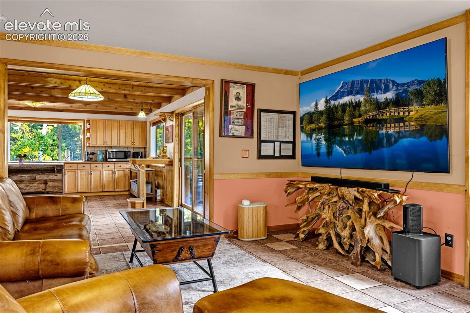 Living area featuring tile flooring, wood-trim accents, and exposed wooden ceiling beams