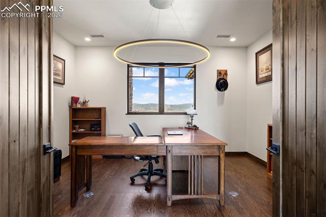 Main-level office with double door entry, built-inbook shelves, and mountain views.