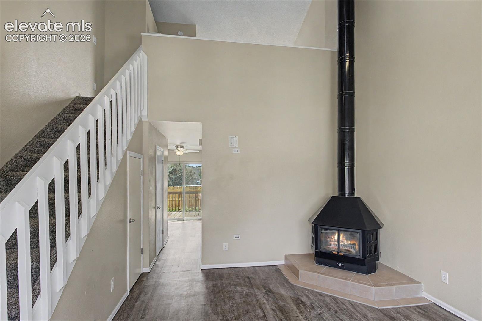 The Living Room has vaulted ceilings, luxury vinyl flooring, and a wood burning stove fireplace which serves as the heart of the home!