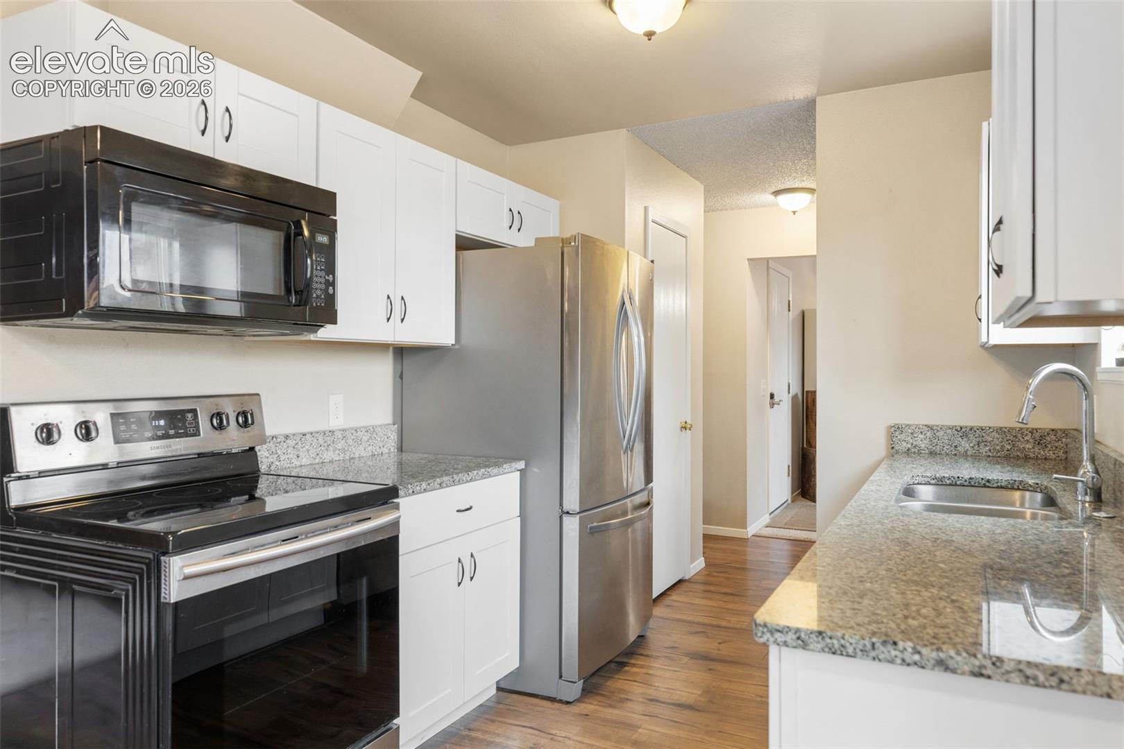 Kitchen updates include newer cabinets, appliances, and granite countertops