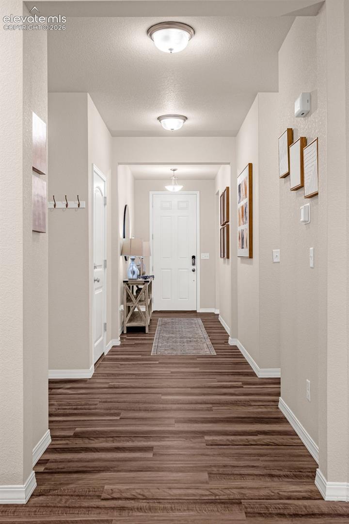 Hallway with wood-finish flooring, light neutral paint, and recessed lighting fixtures