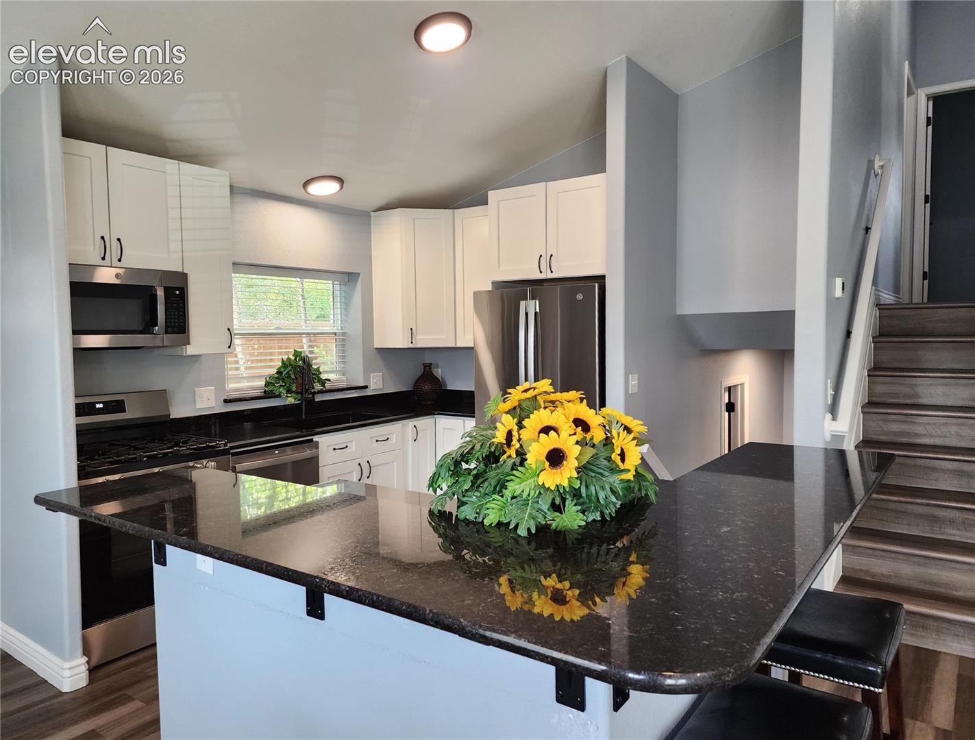 Gourmet kitchen featuring elegant dark granite countertops and ample cabinetry storage
