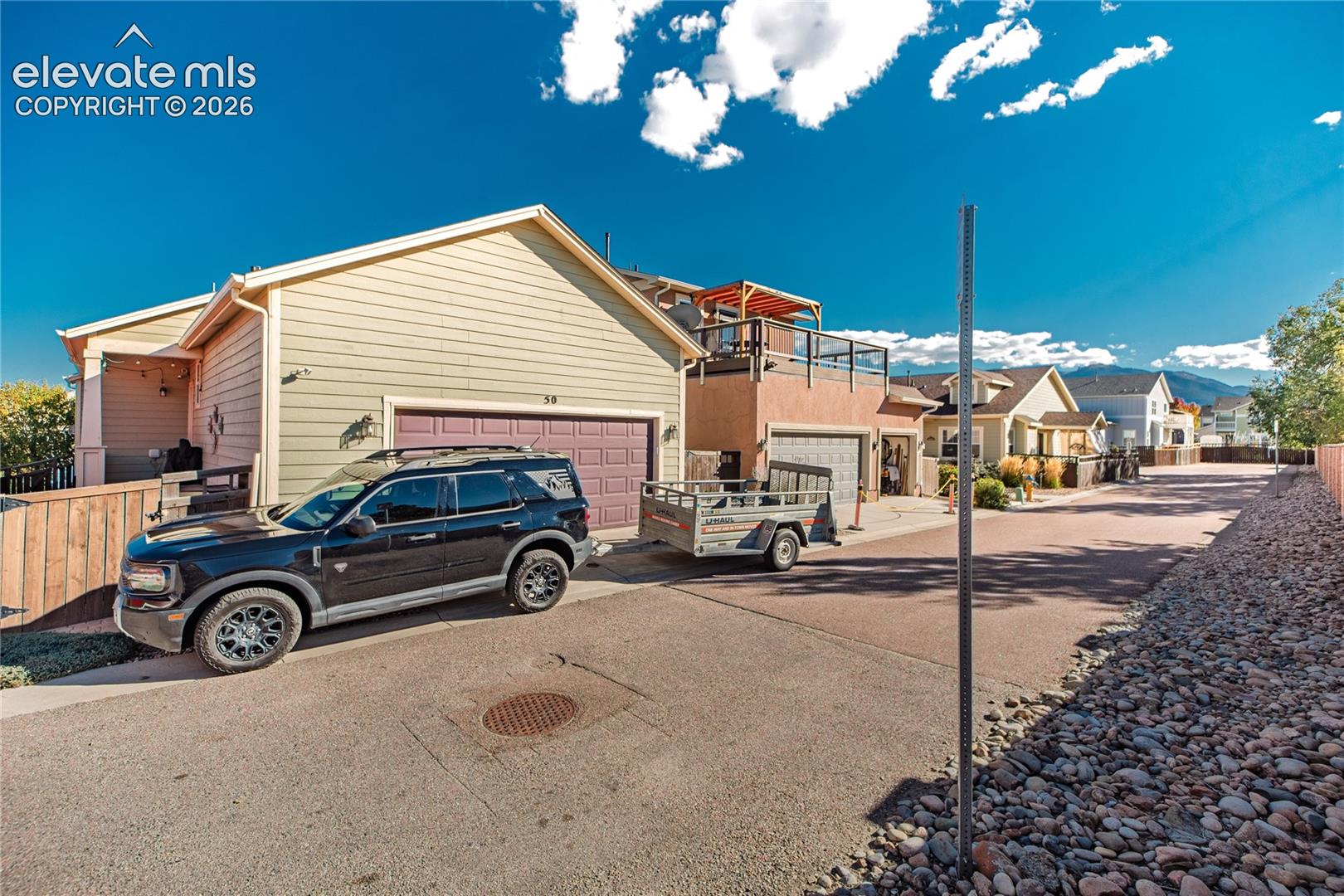 Exterior featuring a horizontal lap siding facade, an attached two-car garage, and an elevated deck with metal railing