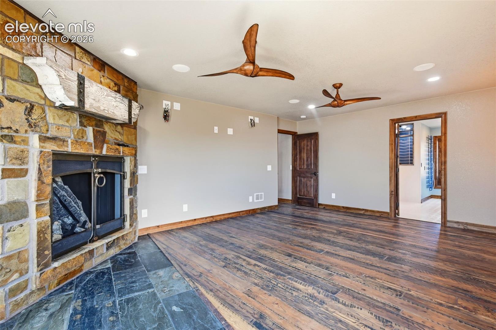 Stone-clad fireplace with a distressed wood mantle