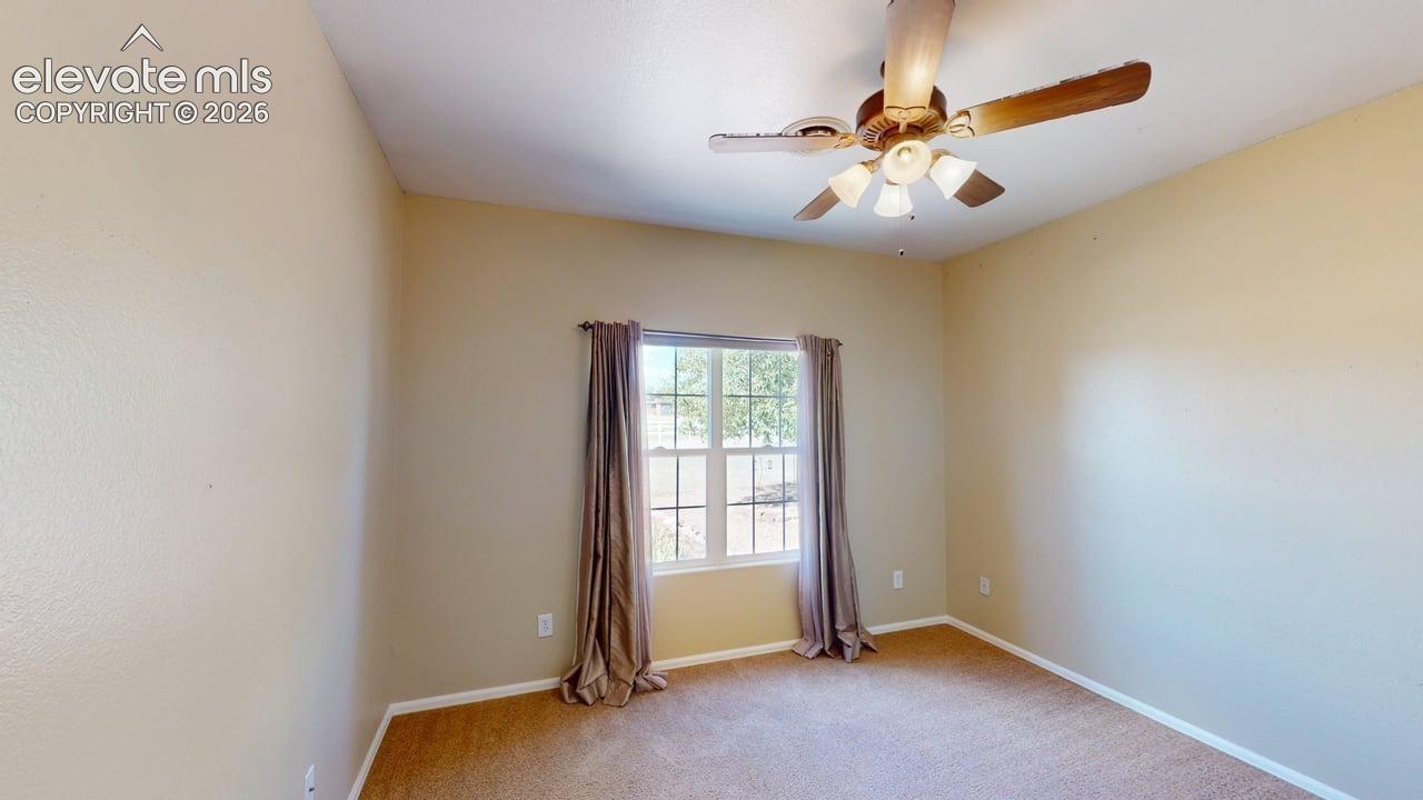 Ceiling fan with integrated lighting, carpeted flooring, and a window with vertical mullions