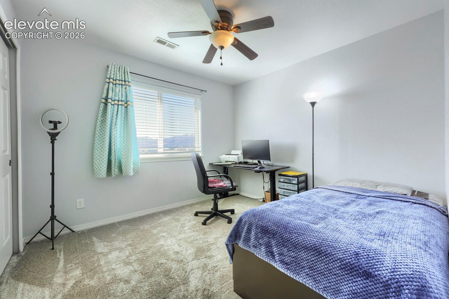 Room featuring neutral wall tones, carpeted flooring, a ceiling fan with integrated lighting, and a window with horizontal blinds