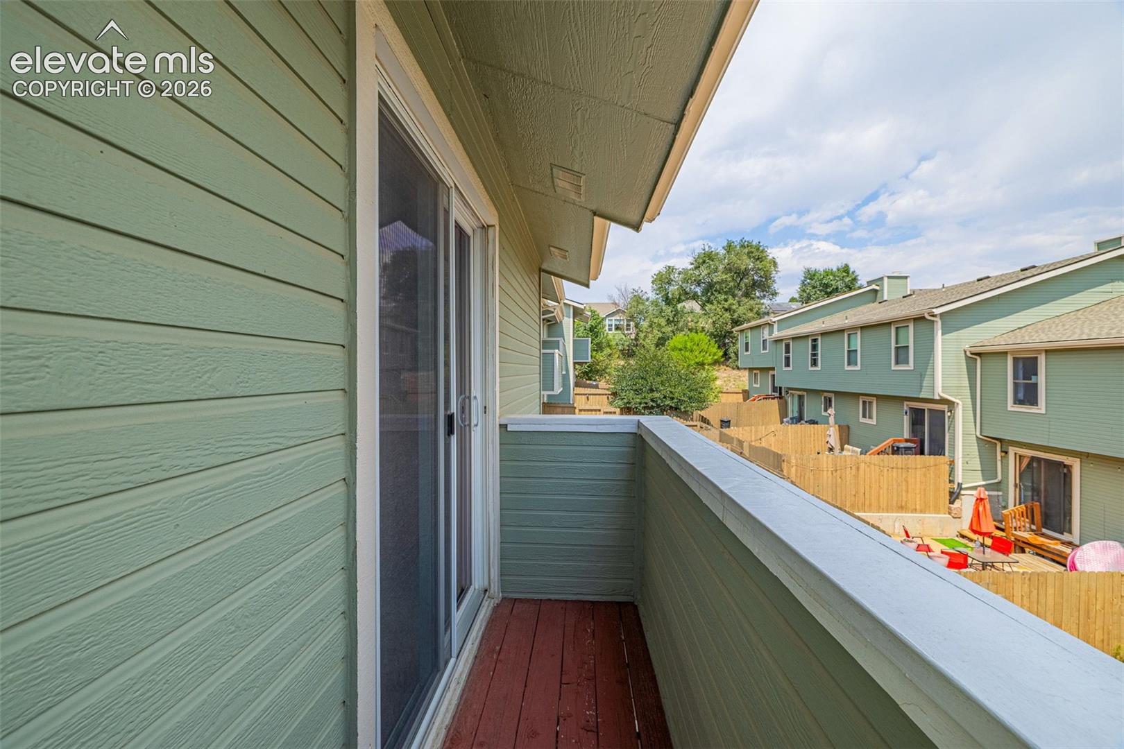 Private balcony featuring wood-finish flooring and a sliding glass door
