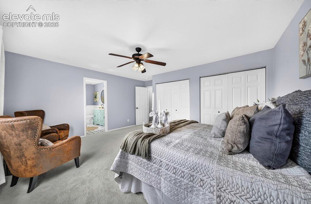 Neutral-toned carpeting, ceiling-mounted fan with integrated lighting, and dual bifold closet doors