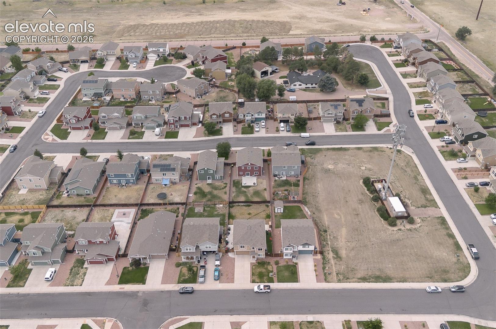 Aerial rear view home, backyard, and neighborhood.