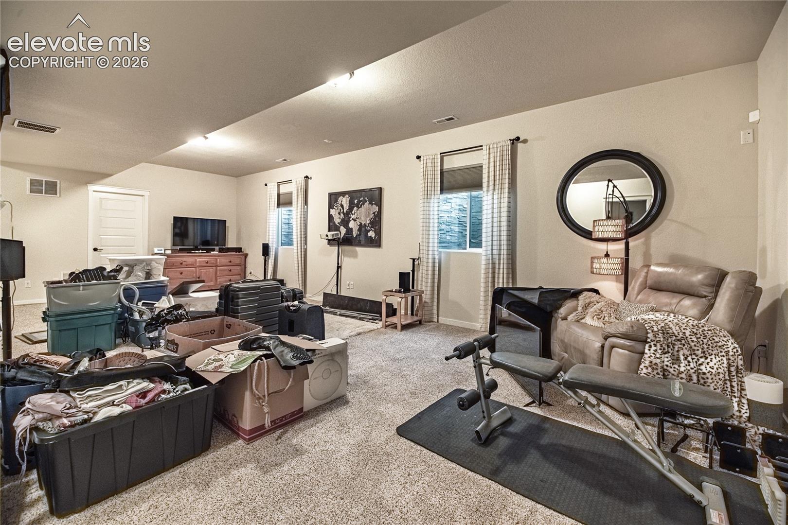 Open-concept room featuring wall-to-wall carpeting, recessed lighting, and dual windows