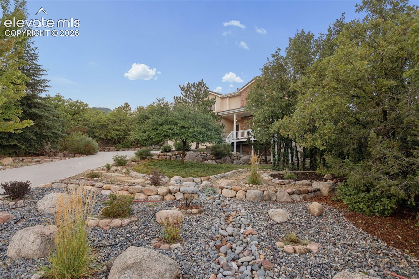 Driveway and mature and meticulous landscaping 
