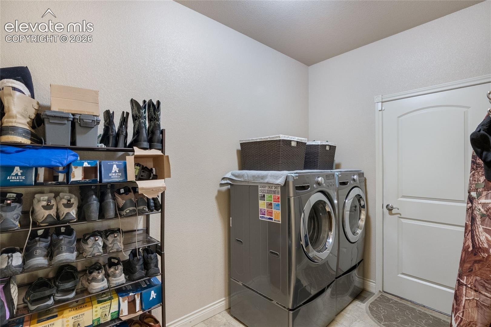 Utility room featuring a dedicated laundry area with neutral wall tones, and a solid-core interior door to garage