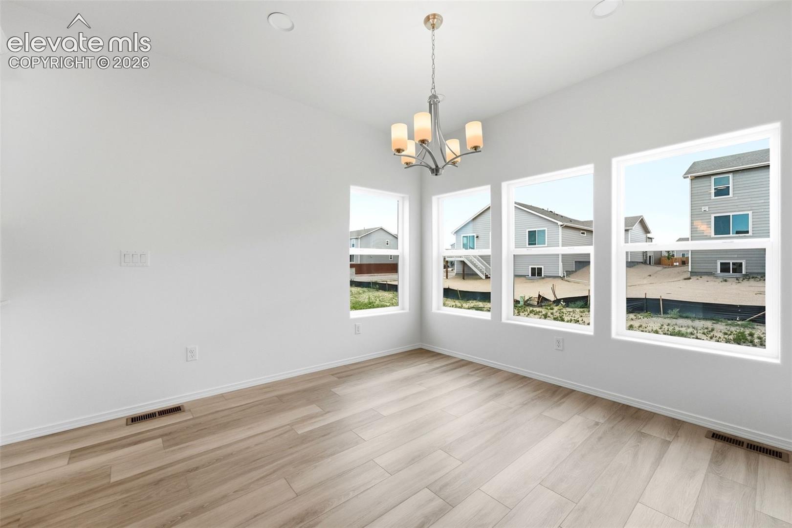 Wood-finish flooring, multi-pane windows, and a multi-arm chandelier fixture