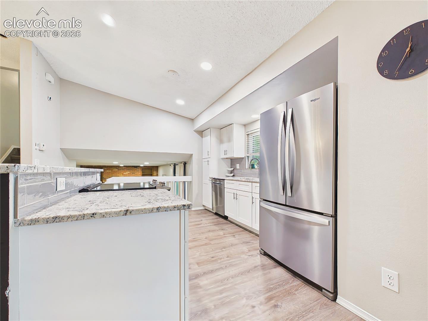 Kitchen with Breakfast Bar – Large granite-topped breakfast bar offers comfortable seating, generous workspace, and a welcoming centerpiece for casual dining.