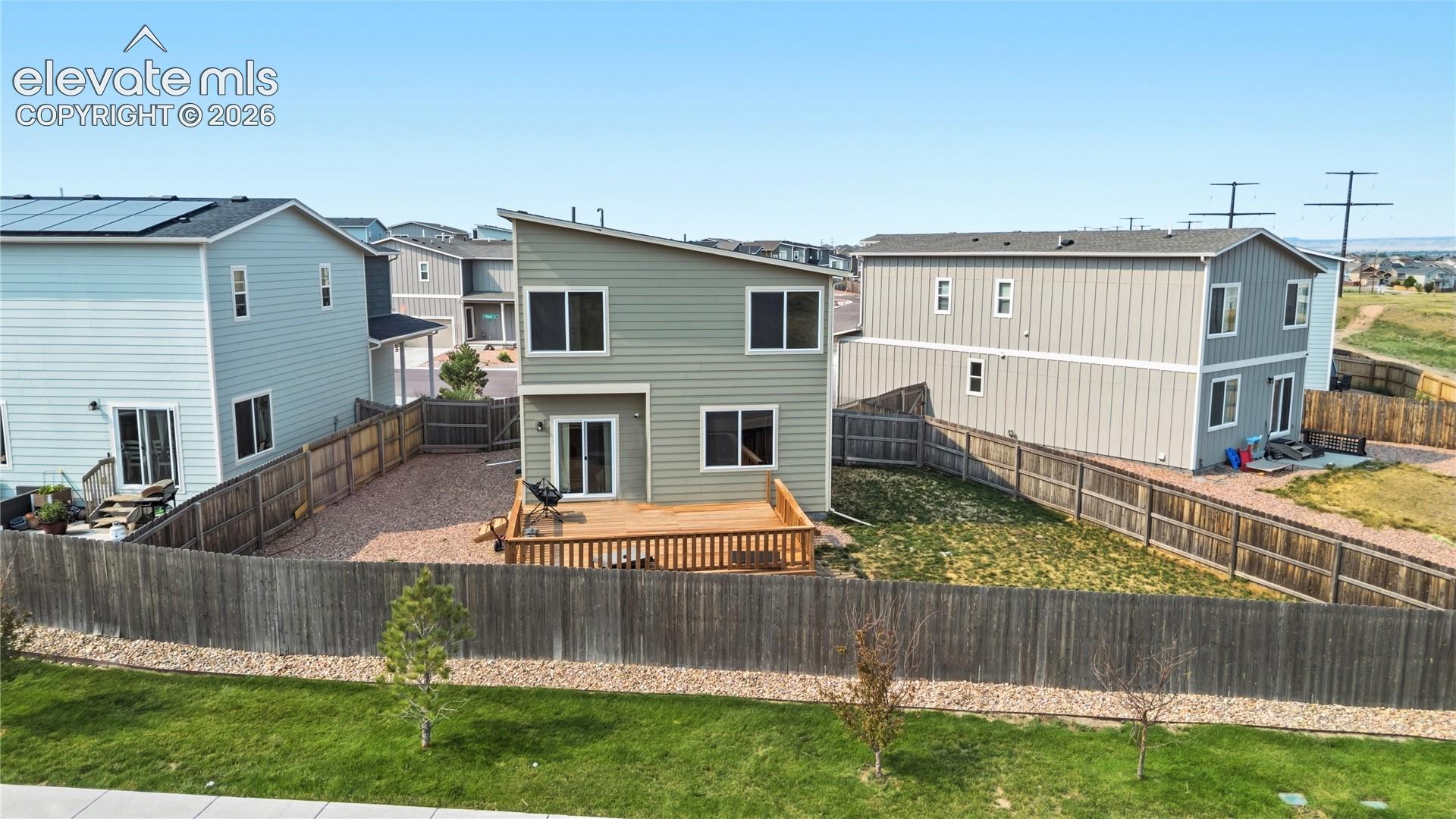 Aerial rear view of home and fenced backyard.