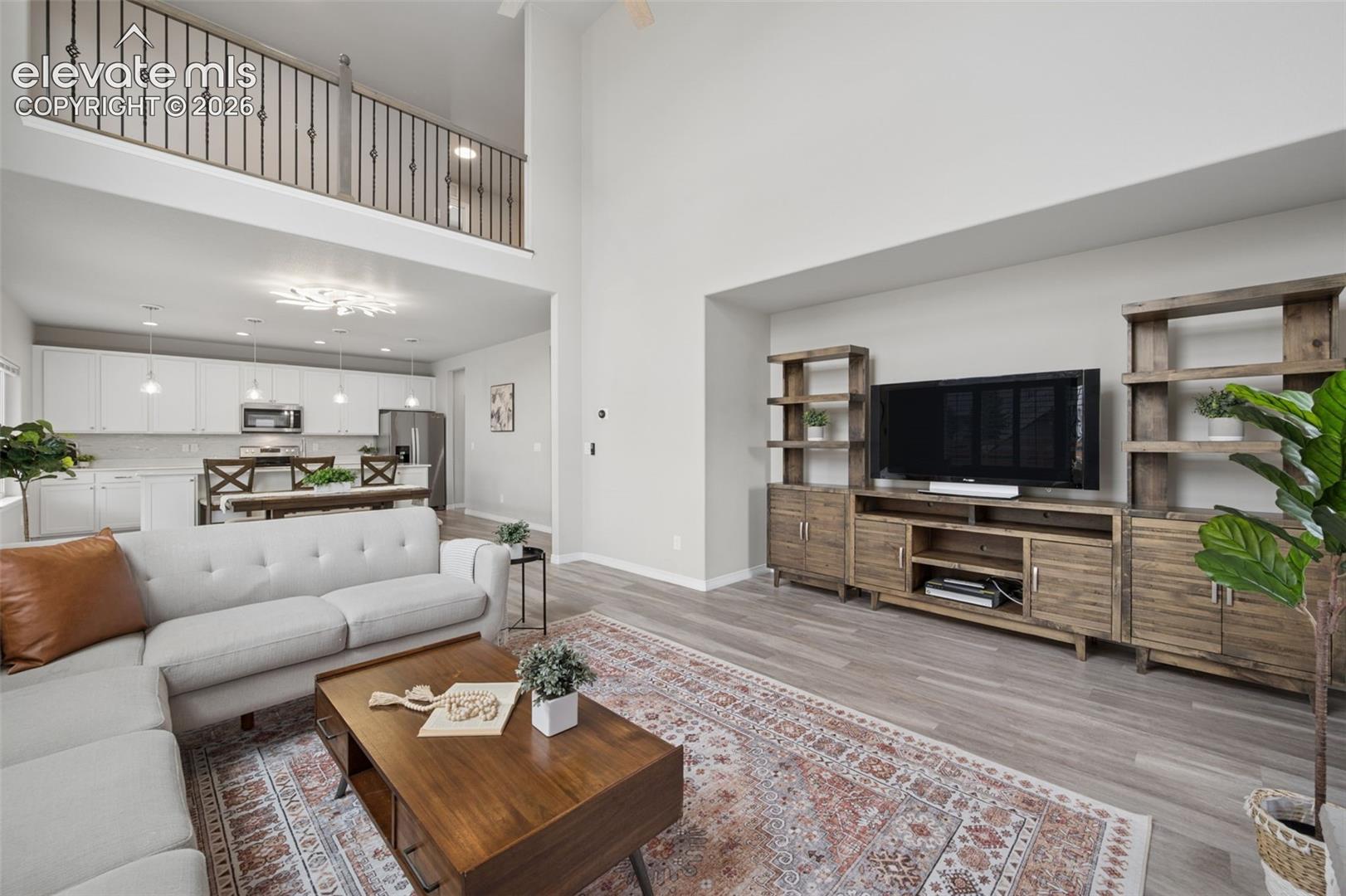 Open-concept living space with high ceilings and wood-finish flooring