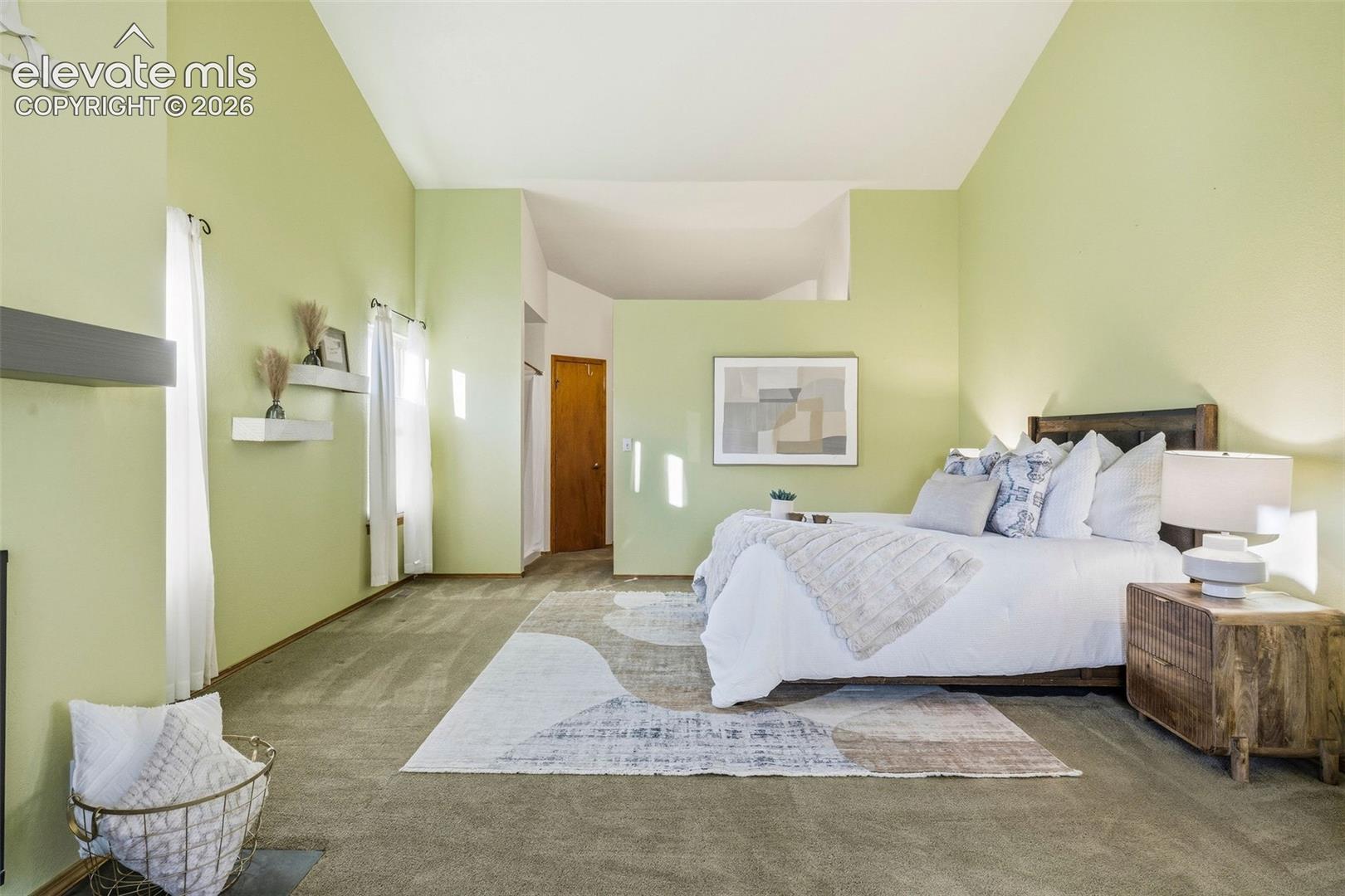 Vaulted ceiling, carpeted flooring, and wall-mounted floating shelves