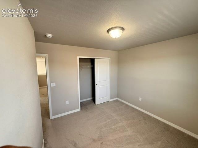Carpeted flooring, neutral wall tones, flush mount ceiling light, sliding closet doors, built-in closet shelving