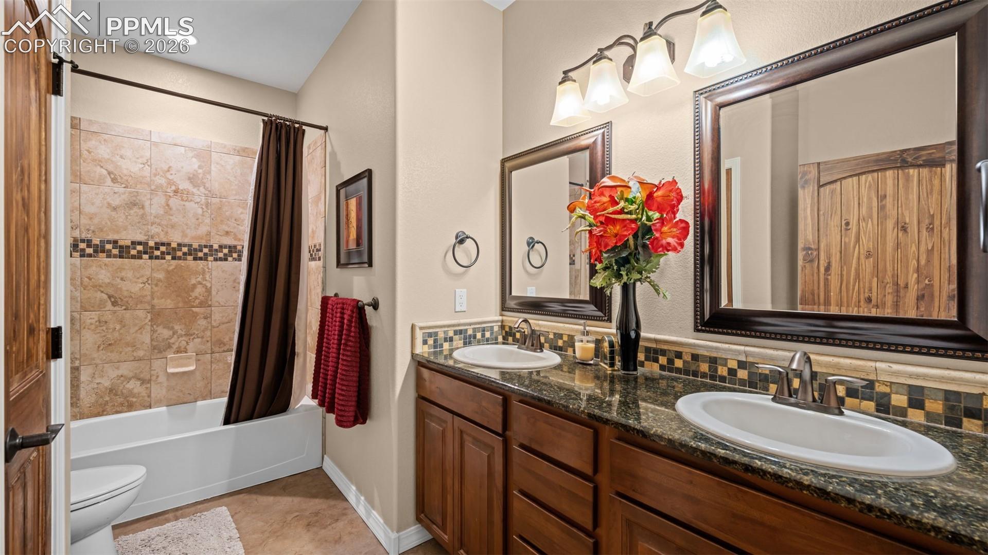 Bathroom with double vanity and shower / tub combo