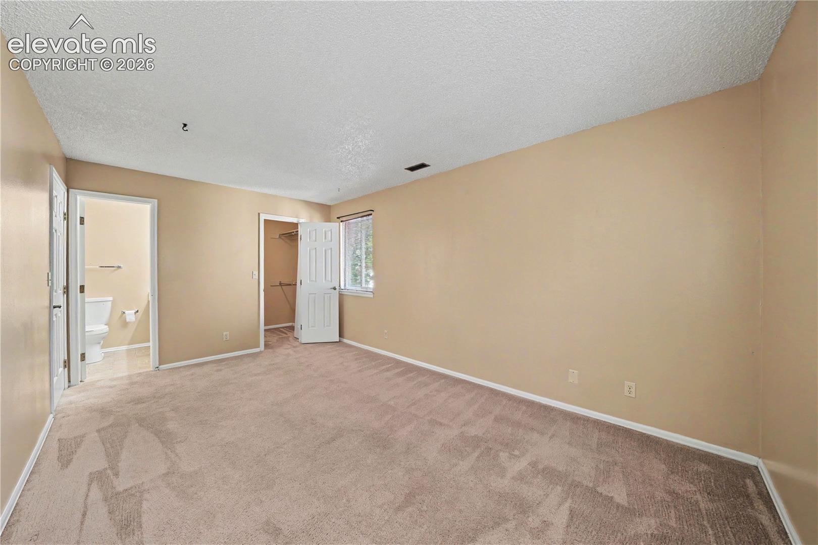 Carpeted bedroom with neutral walls