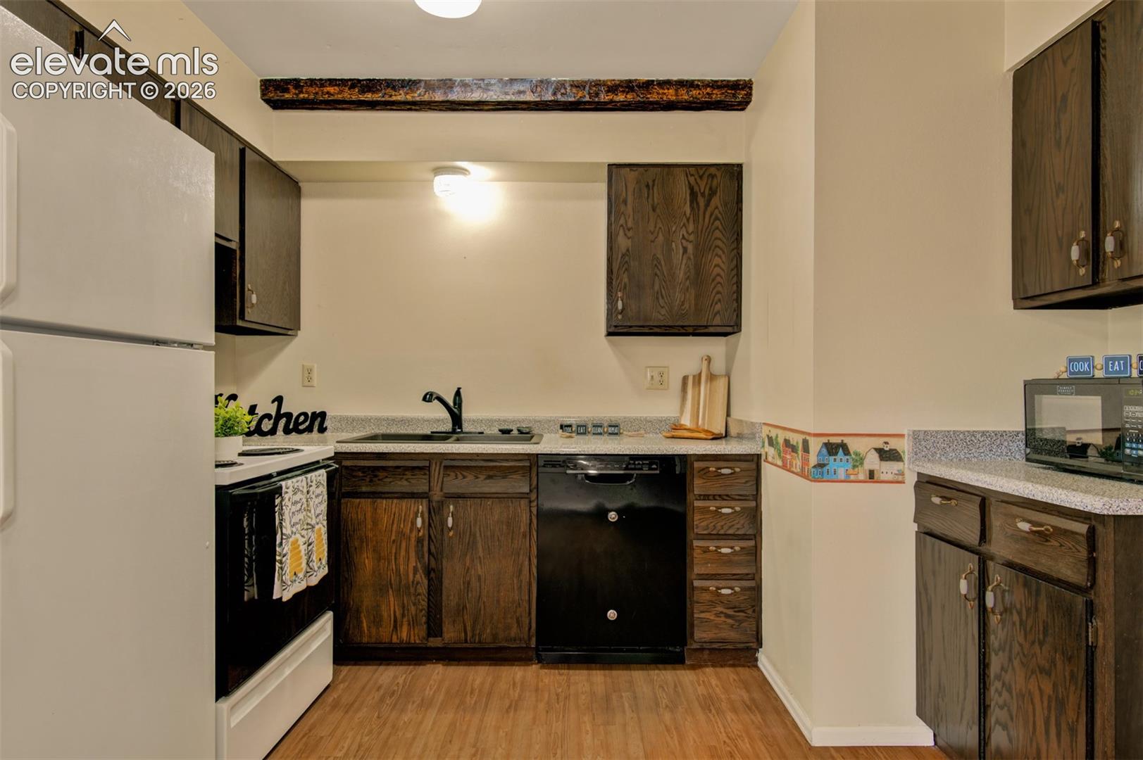 Kitchen featuring dark wood-finish cabinetry, granite countertops
