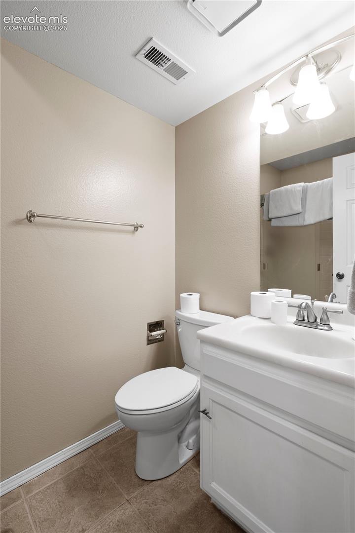 White vanity with integrated sink, chrome faucet, and storage cabinetry
