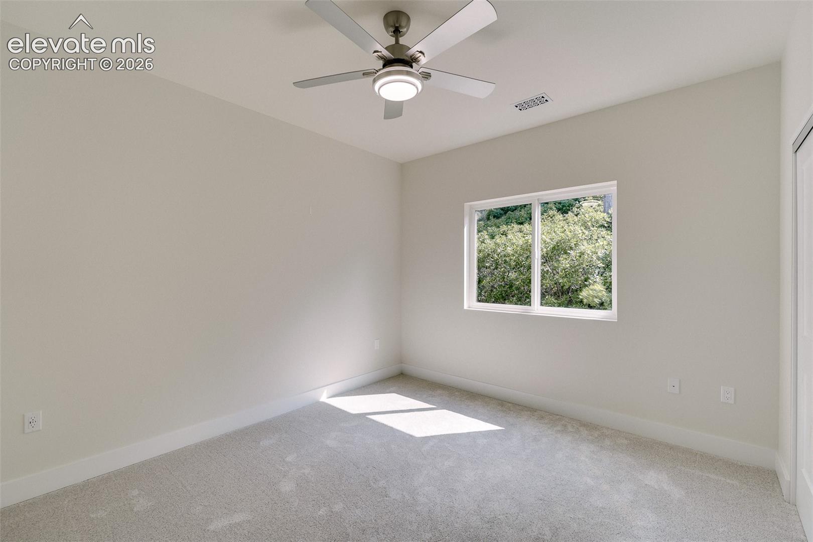 Upper Level Bedroom #5 with neutral carpet and a lighted ceiling fan.