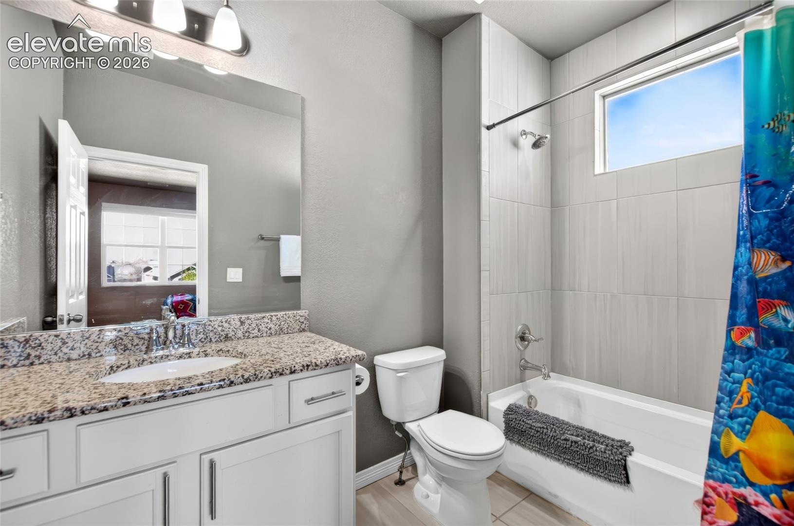 Vanity with a speckled countertop, undermount sink, and chrome faucet