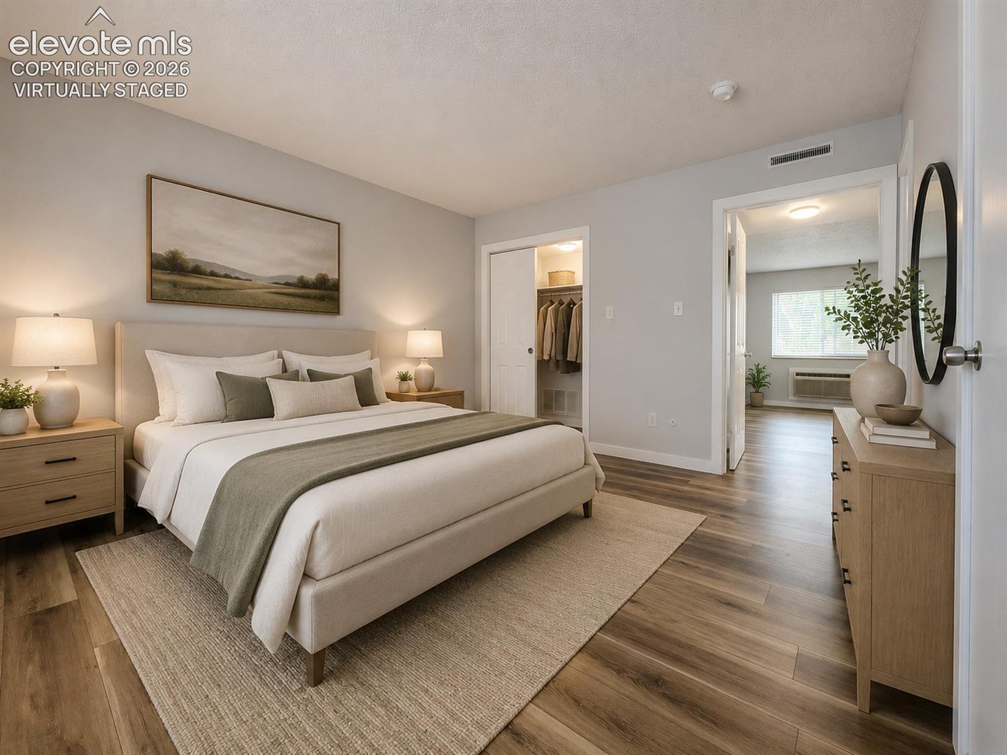 Virtually staged Primary Bedroom featuring wood-finish flooring, and his & hers closet