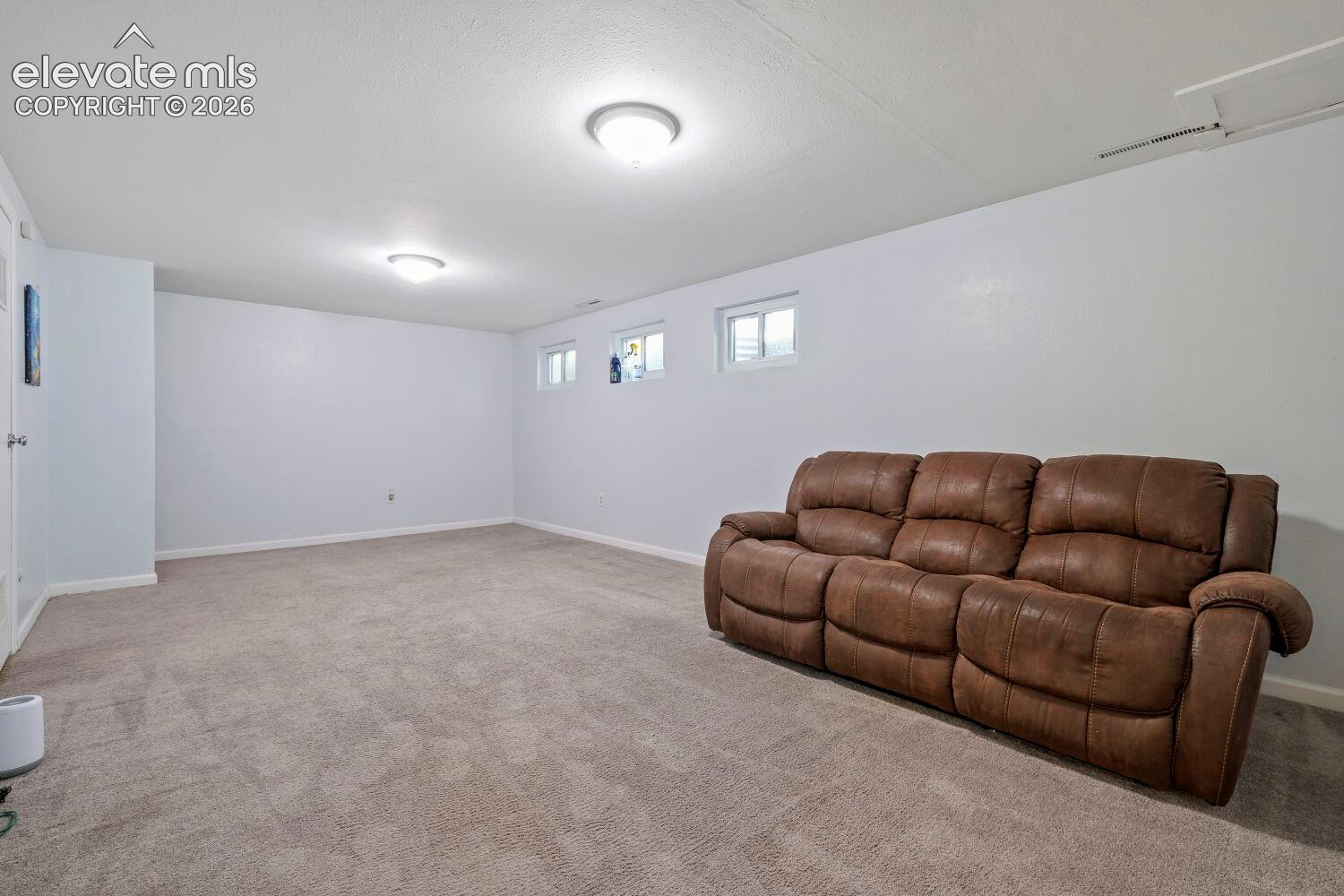 Spacious room featuring neutral carpeting, light-colored walls, and recessed lighting