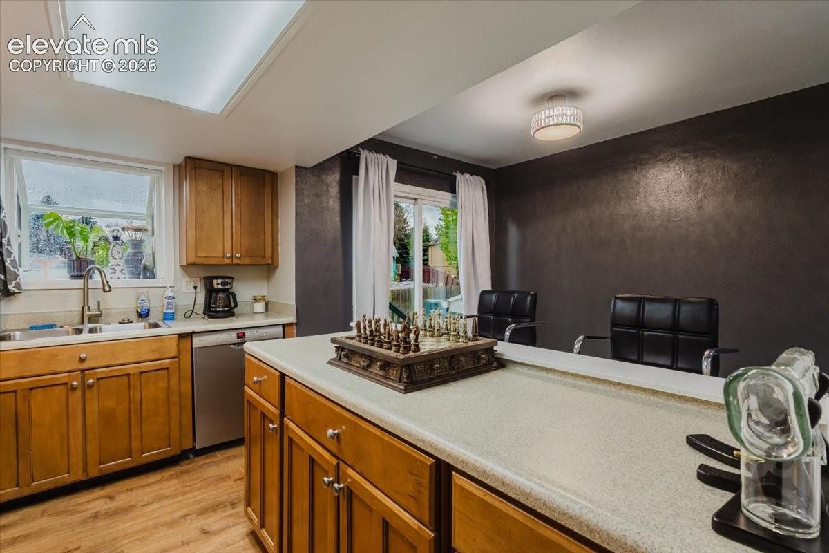 Kitchen with wood-finish flooring, recessed lighting, and a skylight