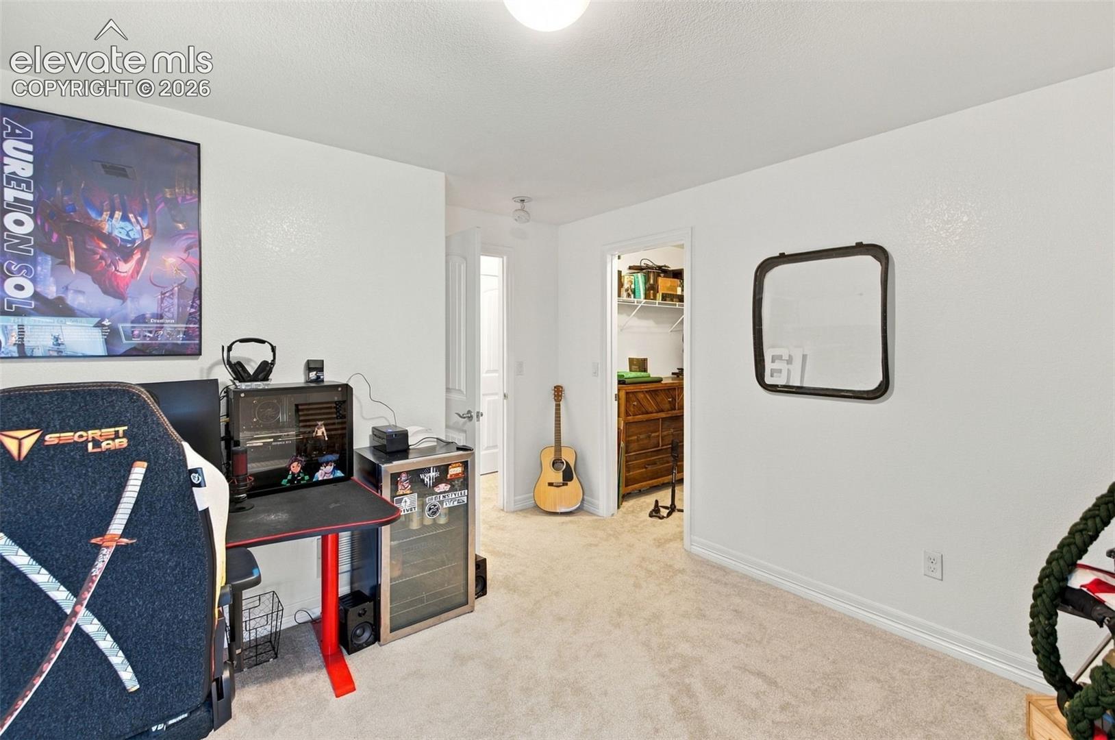 Room featuring neutral-toned carpeting, crisp white walls, and a recessed reach-in closet with wire shelving