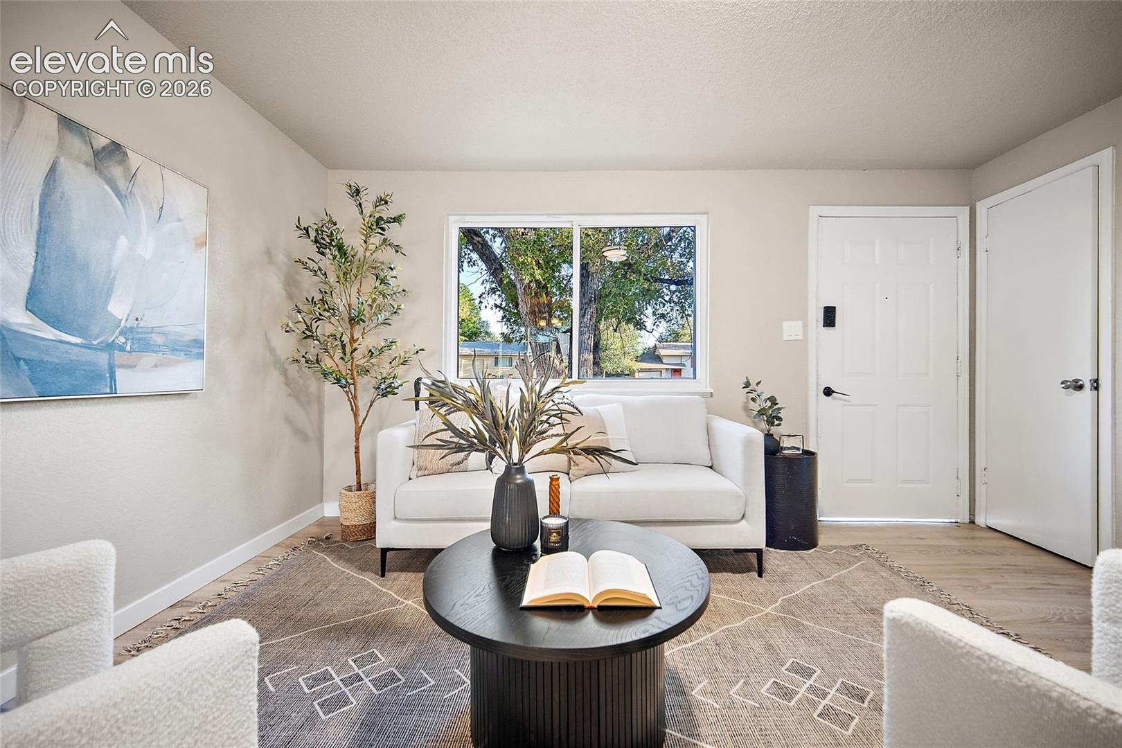 Recessed window with exterior views, light wood-finish flooring, and neutral wall tones