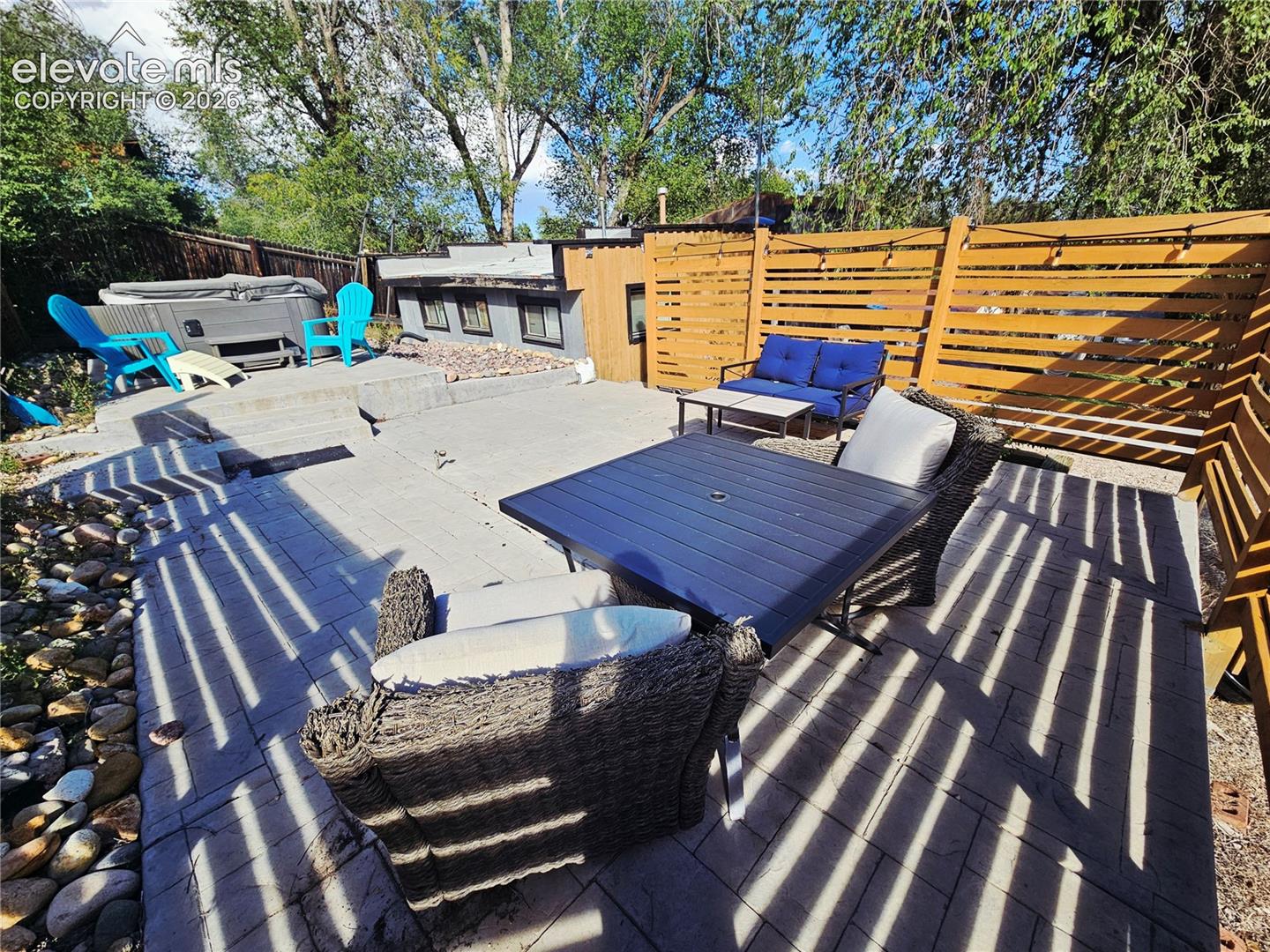 Multi-level stamped concrete patio with privacy fencing, and spa