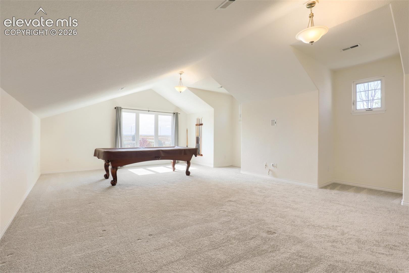 Expansive soundproofed upper-level great room boasting architectural vaulted ceilings, plush carpeting, and bright windows. This massive bonus space includes a private closet—offering endless potential as a media room, play area, or oversized bedroom suite.